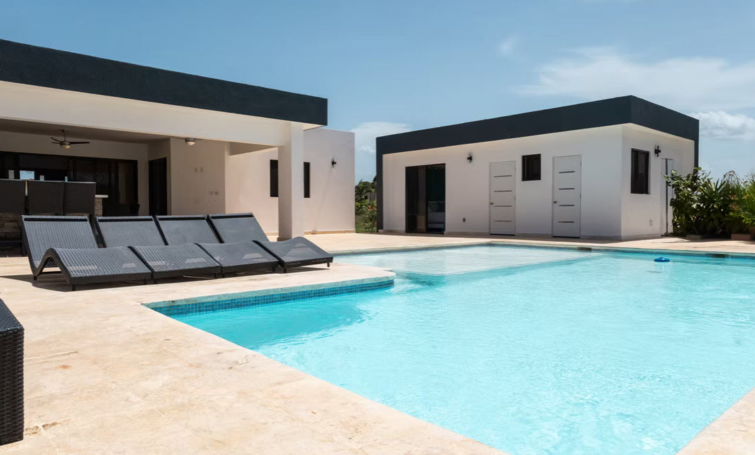 Modern luxury villa with a large private pool and lounge chairs