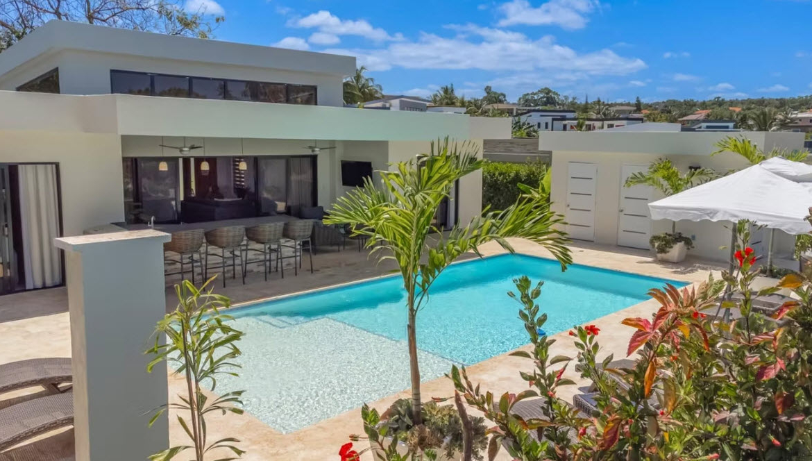 Modern villa with pool, swim-up bar, and tropical landscaping