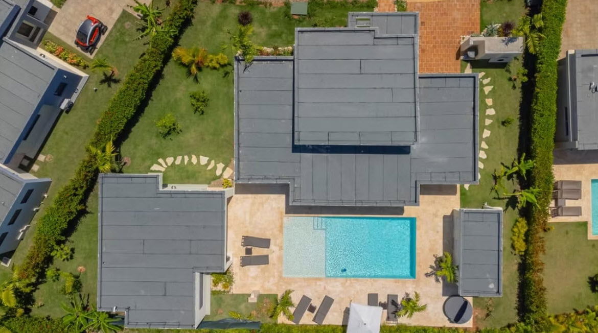 Aerial view of a modern villa with a swimming pool and sun loungers