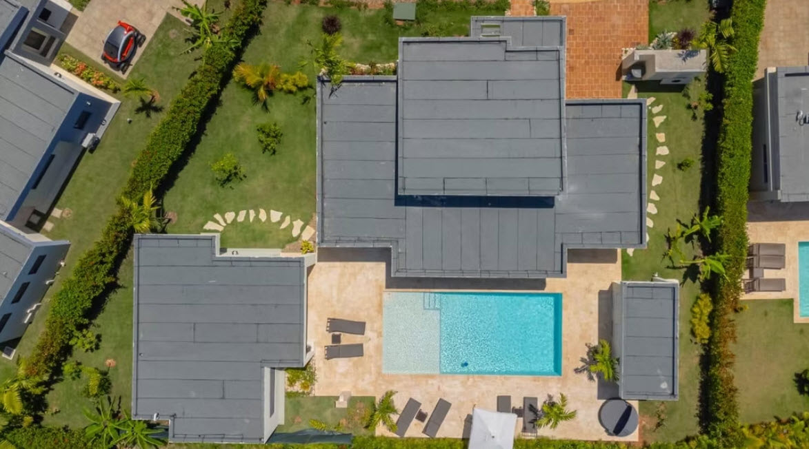 Aerial view of a modern villa with a swimming pool and sun loungers