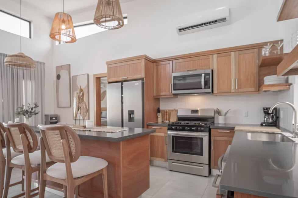Modern kitchen with wooden cabinets, stainless steel appliances, and island seating