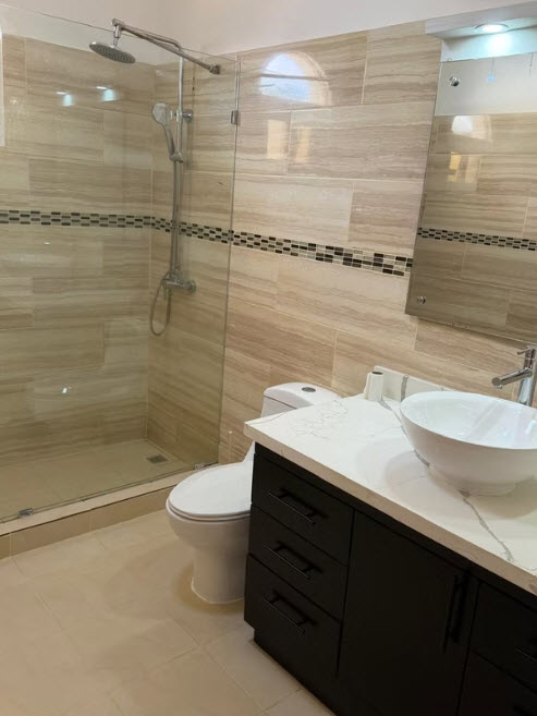 Modern bathroom with walk-in shower, vanity, and toilet