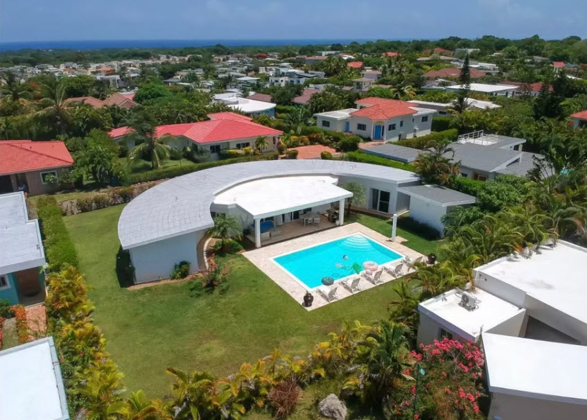 Modern Barbados villa with curved roof, private pool, and ocean view