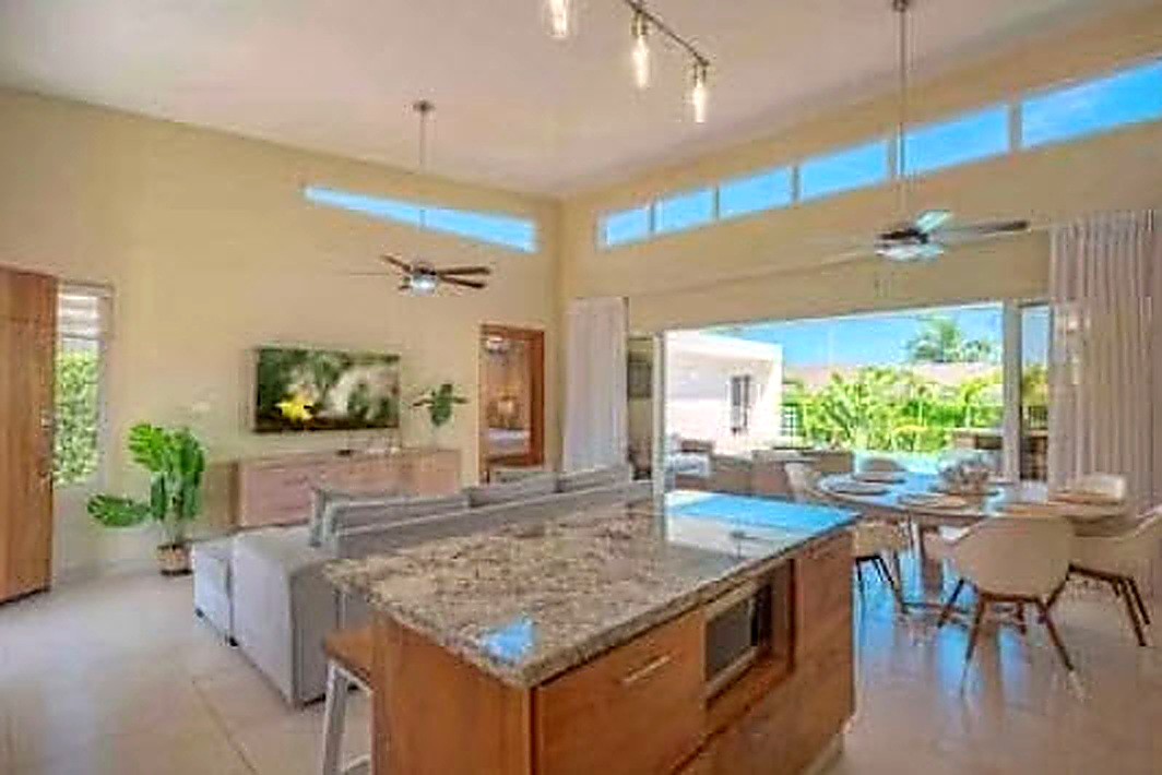 Modern living room with kitchen island and view of pool