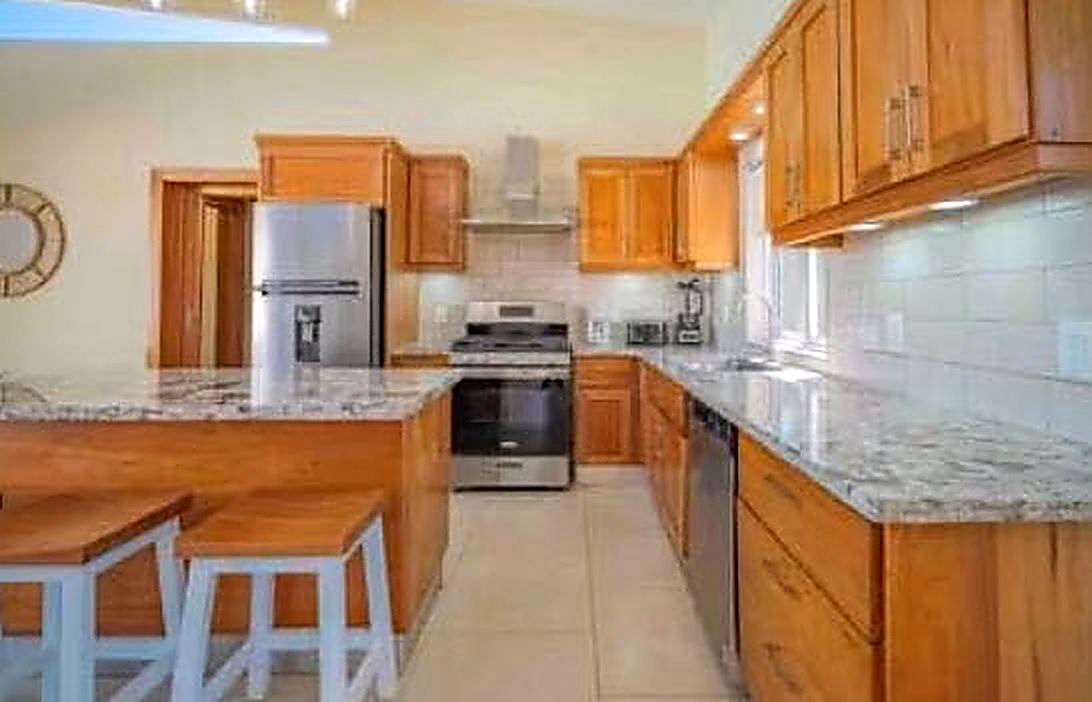 Modern kitchen with wood cabinets, stainless steel appliances, and granite countertops