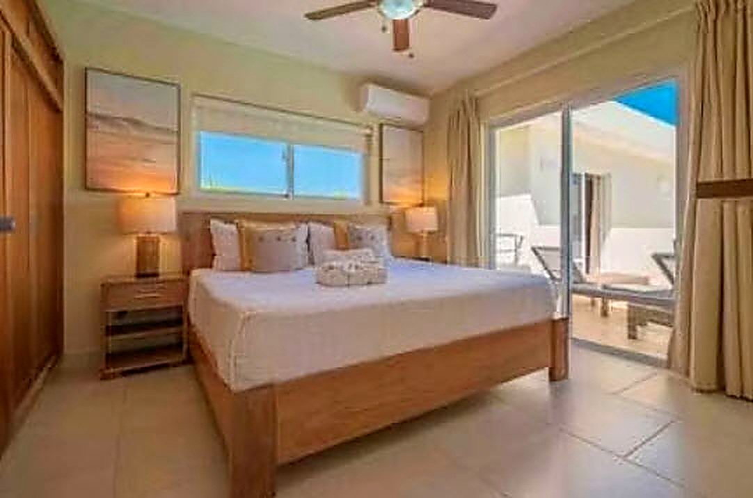 Luxurious bedroom with king-size bed, artwork, and balcony access