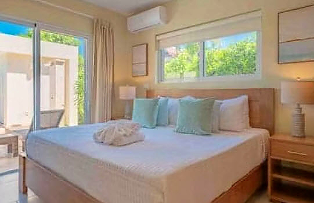 Bright bedroom with king-size bed and ocean view window
