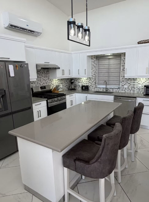 Modern kitchen with large island, bar stools, and stainless steel appliances