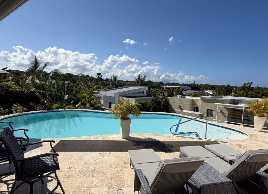 Luxury villa with infinity pool overlooking tropical landscape in sunny weather