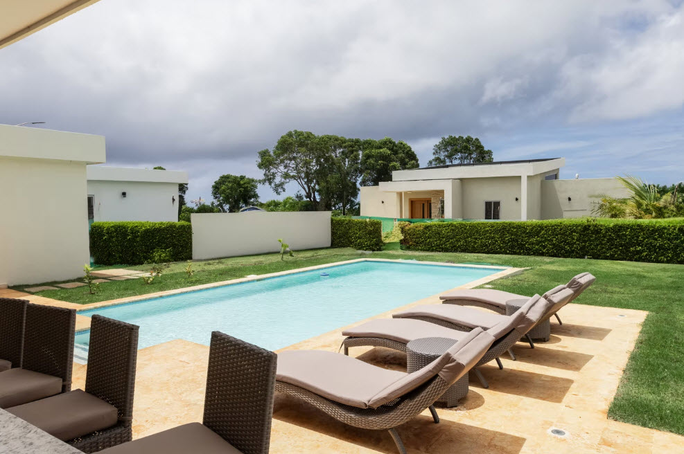 Luxury villa with swimming pool and lounge chairs on a sunny day