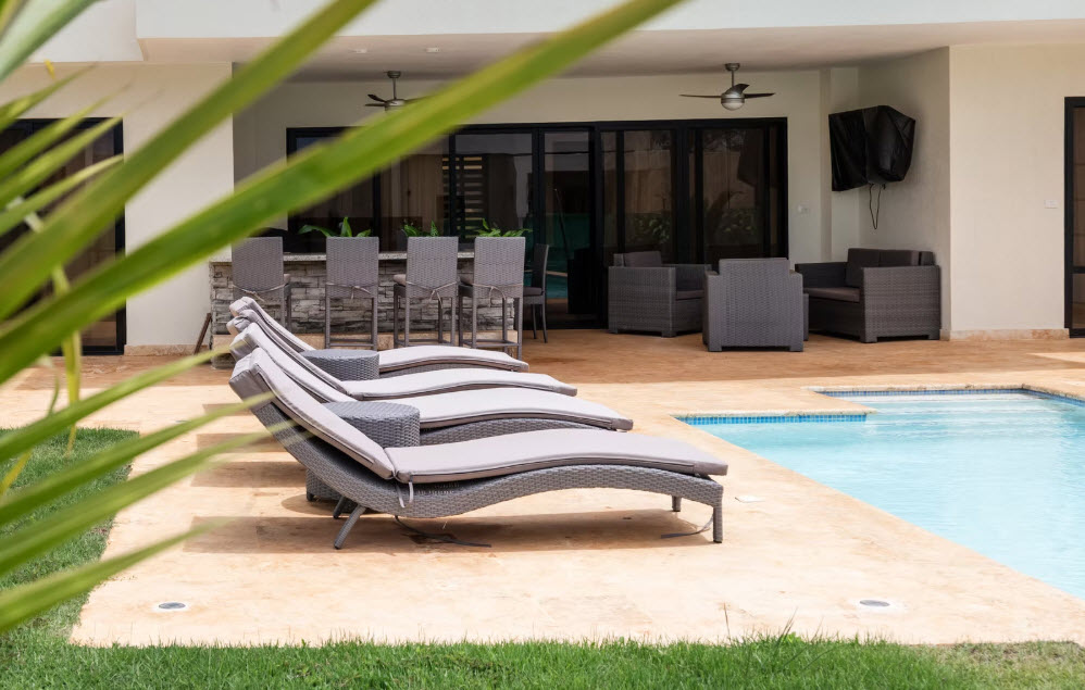 Luxury resort pool with lounge chairs, bar, and seating area