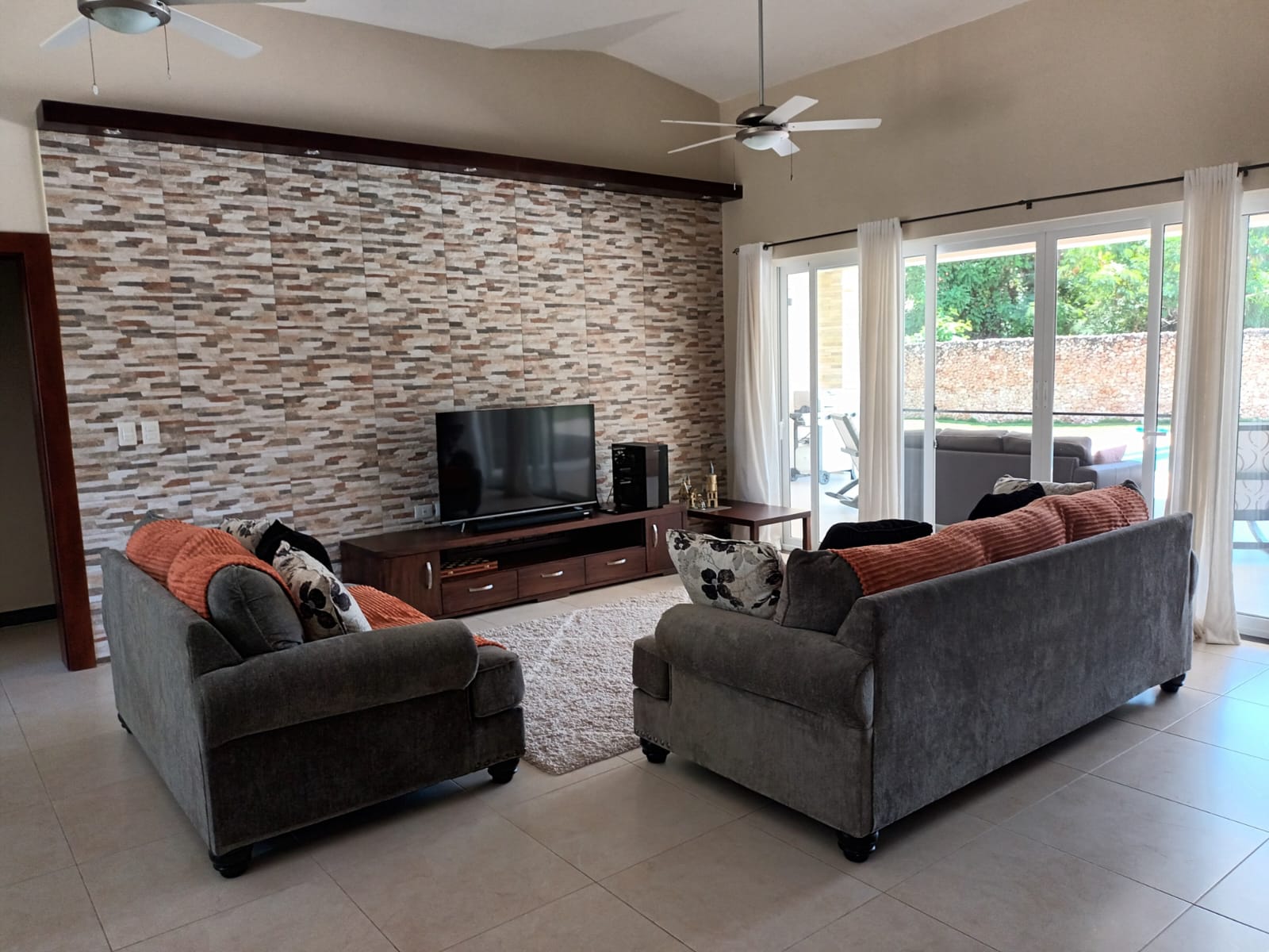 Modern living room with two sofas, TV, and accent wall