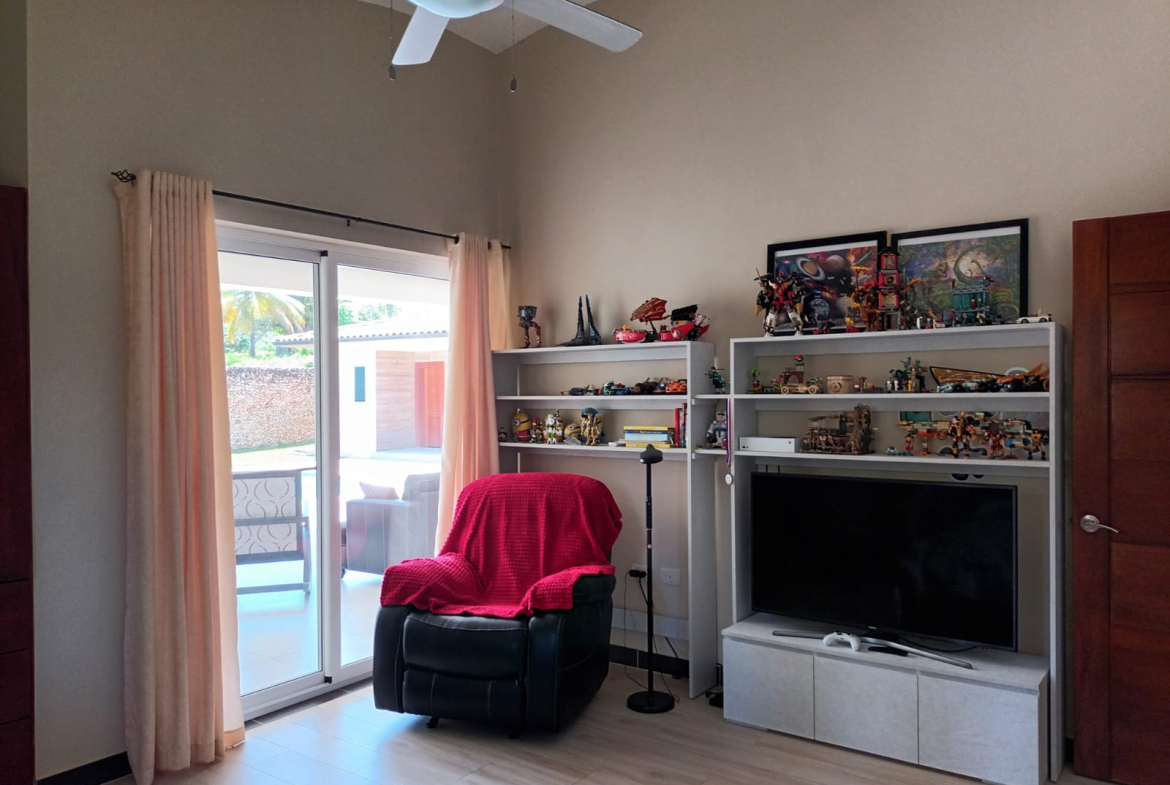 Living room with recliner, TV, and shelves of Lego sets.