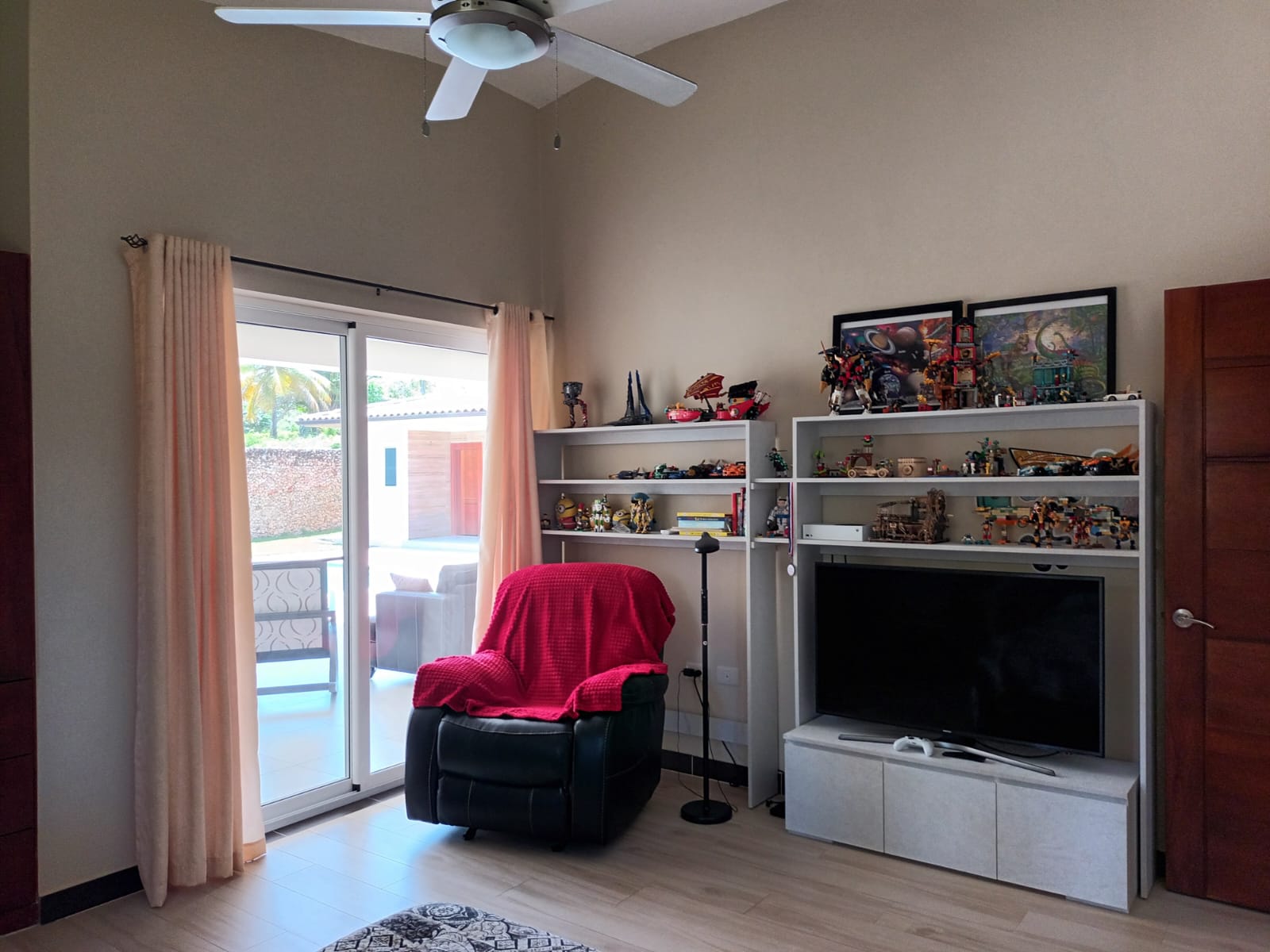 Living room with recliner, TV, and shelves of Lego sets.
