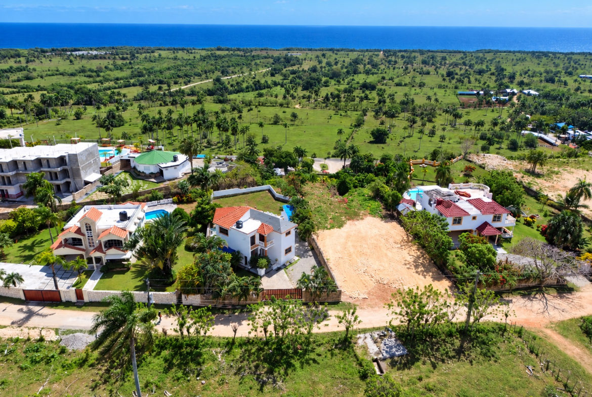 Aerial view of luxury villas with pools and ocean backdrop in a tropical landscape