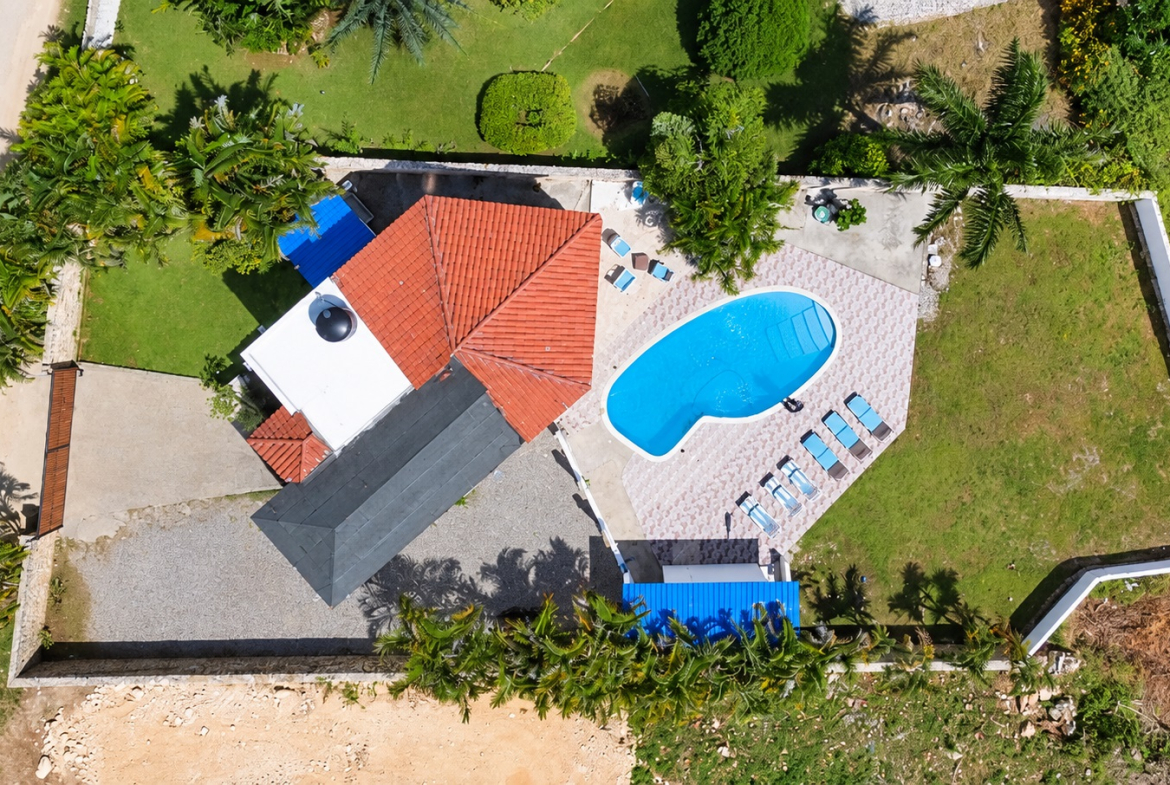 Aerial view of a luxury villa with a swimming pool and lounge chairs