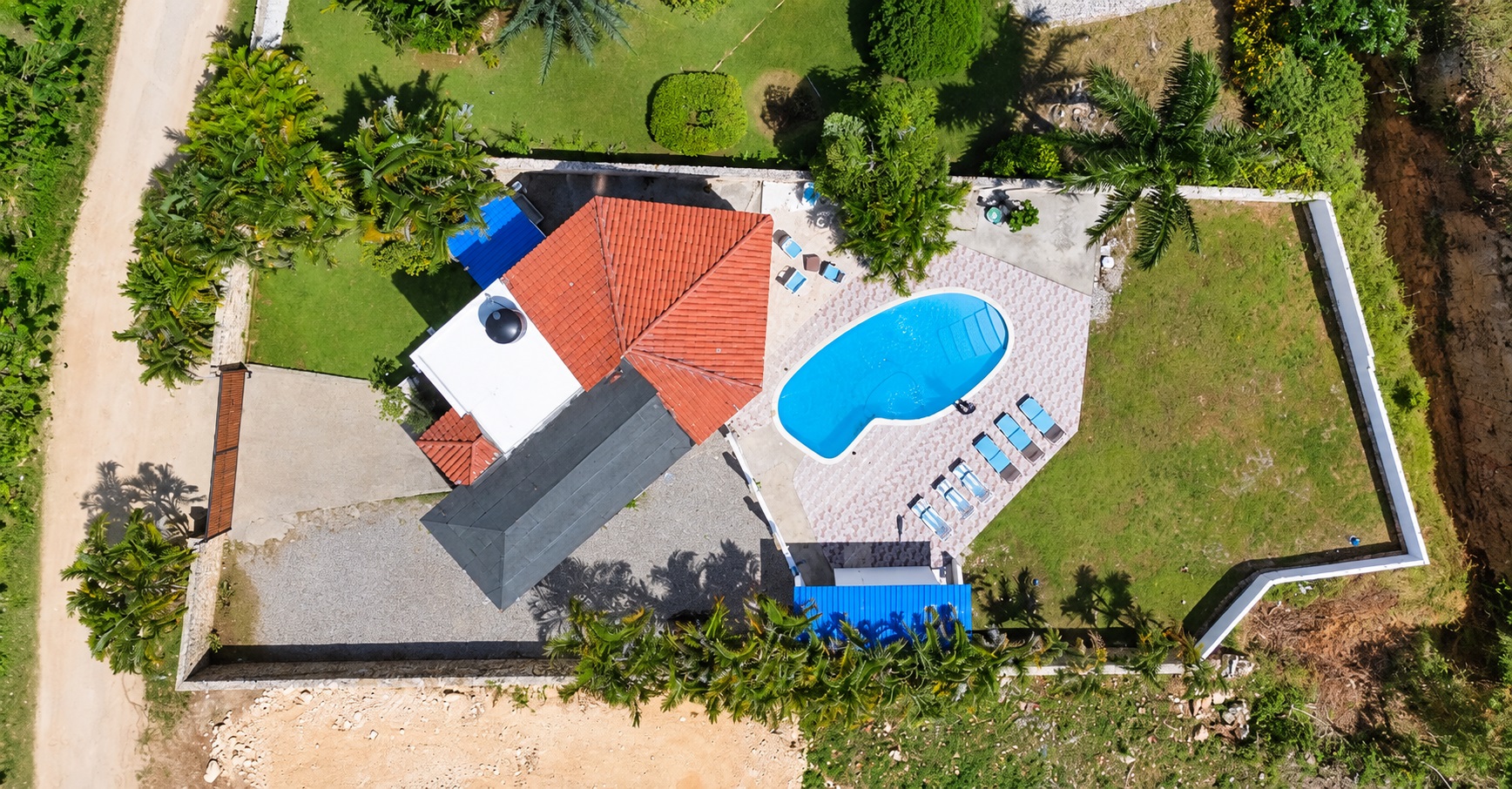 Aerial view of a luxury villa with a swimming pool and lounge chairs